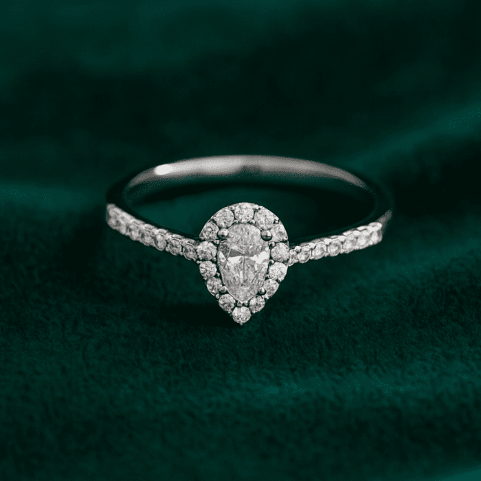 Planet Genesis - Pear-shaped diamond halo ring with pavé diamond band, set in white metal, displayed on dark green velvet. Premium fine jewellery. - IGI-Certified Lab-Grown Diamonds Planet Genesis - Pear-shaped diamond halo ring with pavé diamond band, set in white metal, displayed on dark green velvet. Premium fine jewellery. - IGI-Certified Lab-Grown Diamonds