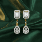 Planet Genesis - Emerald Mirage diamond drop earrings with rectangular and teardrop diamonds, halo-set in white metal, on deep green satin fabric. - IGI-Certified Lab-Grown Diamonds