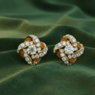 Planet Genesis - The Eternal Knot Diamond Earrings with spiral motifs, pavé diamond setting, shown on lustrous green satin fabric background. - IGI-Certified Lab-Grown Diamonds